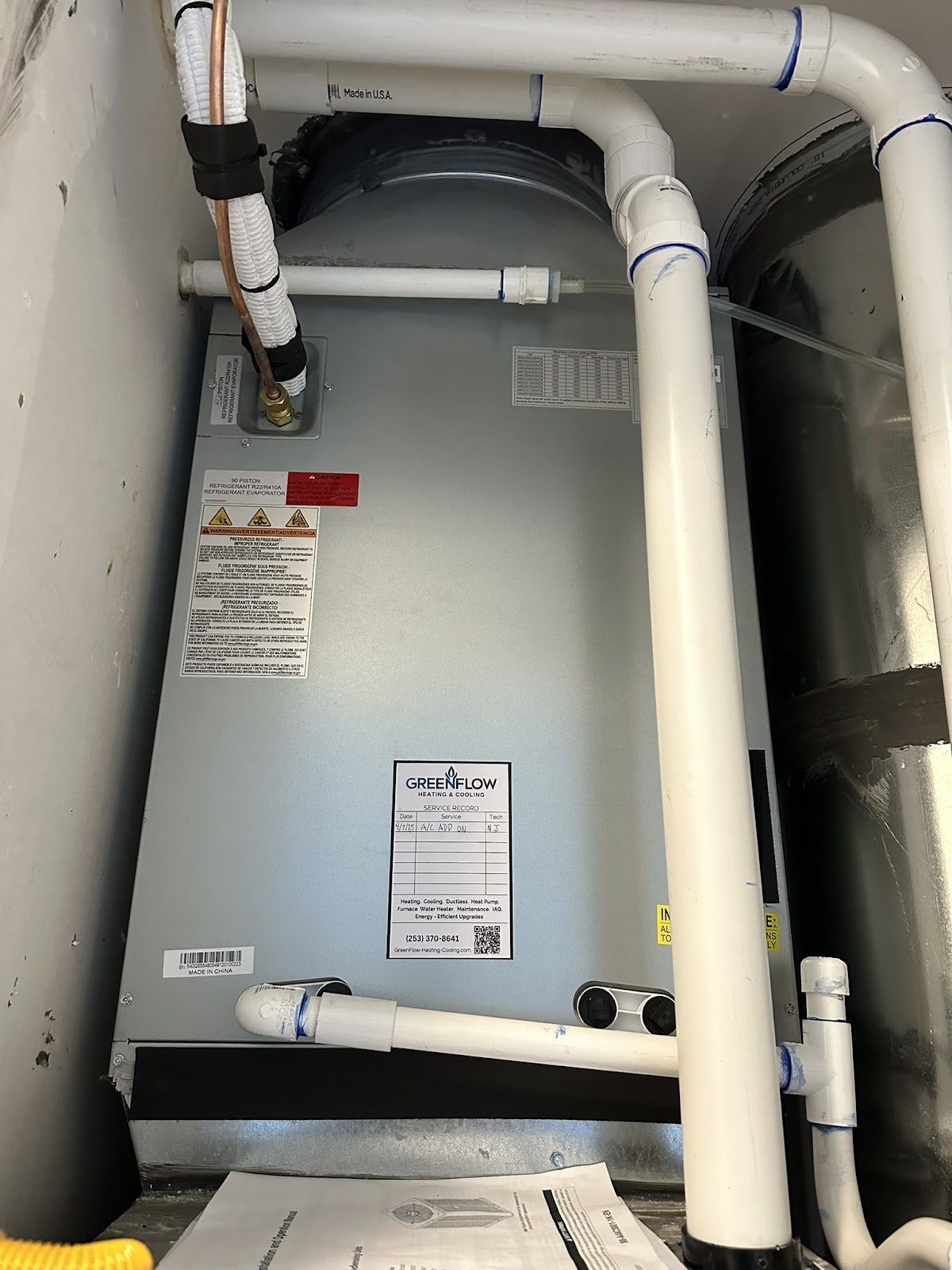 Air handler with GreenFlow branded service sticker and clean PVC condensate routing