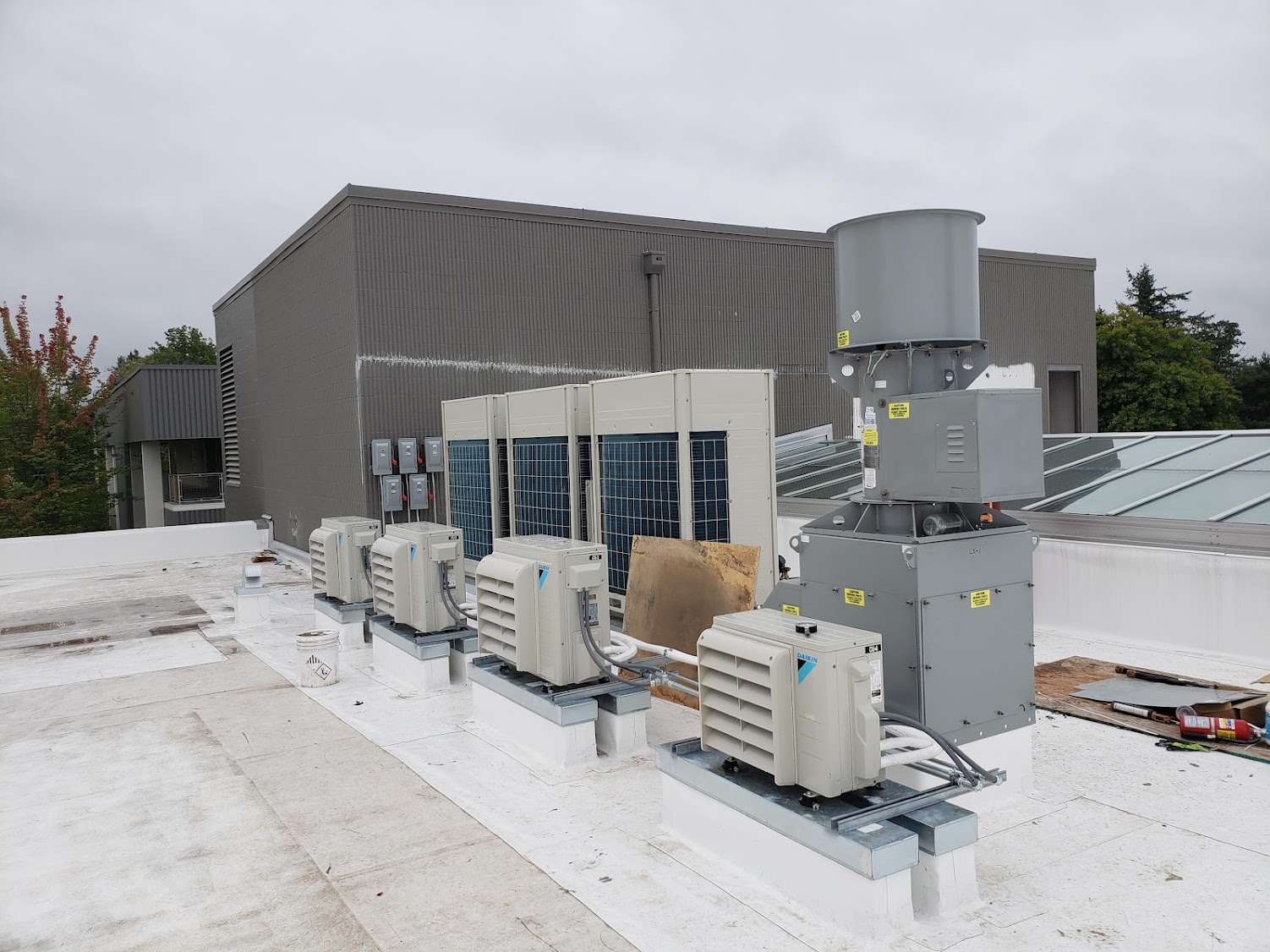 Daikin VRV modular condensers and Daikin ductless mini-split condensers installed by GreenFlow on a Tacoma school rooftop for whole-floor conditioning and dedicated server-room cooling