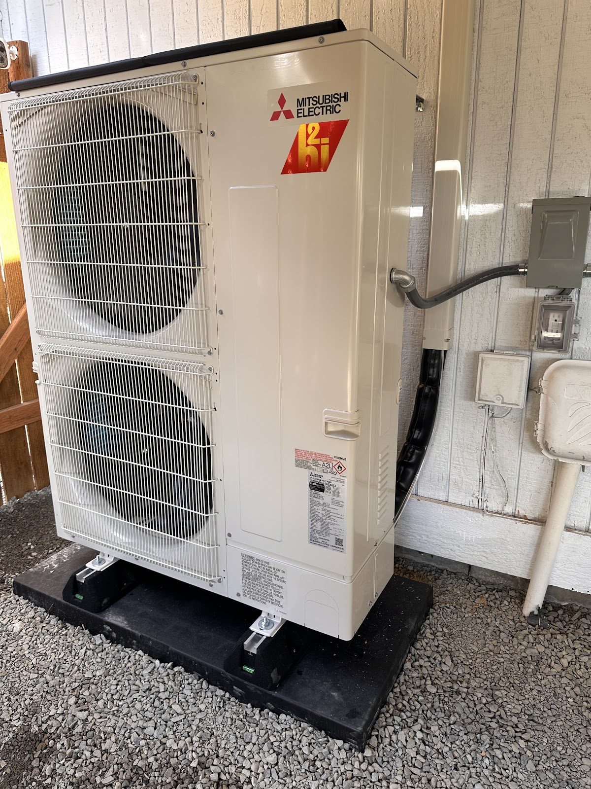 Large Mitsubishi hyper-heat outdoor unit installed on ground pad at a South Sound residence