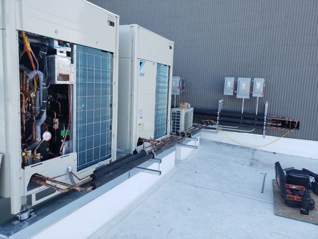 Daikin VRV outdoor units with visible refrigerant piping and disconnects during service by GreenFlow in Pierce County