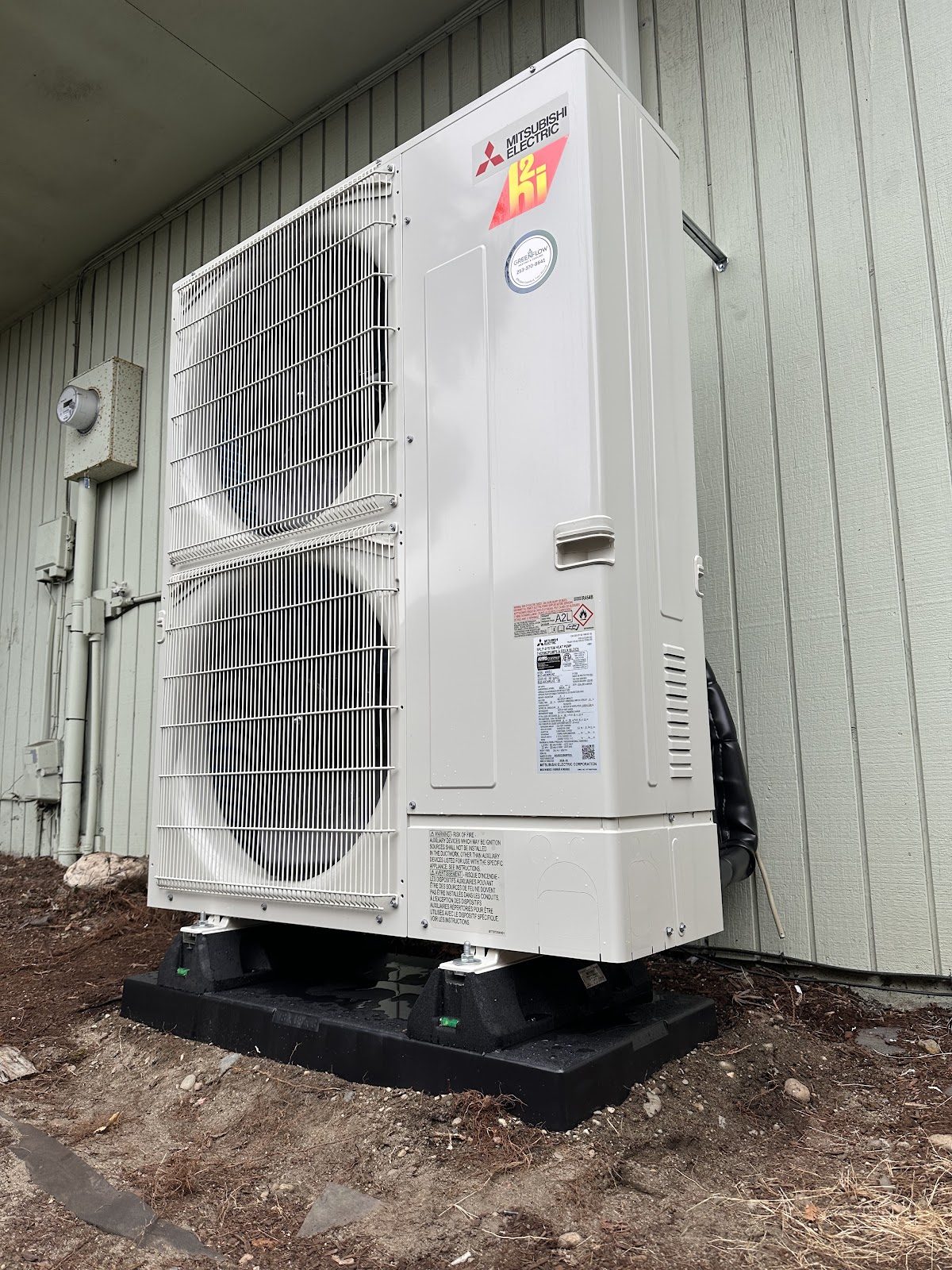 Large Mitsubishi hyper-heat outdoor unit installed on ground pad at a South Sound home