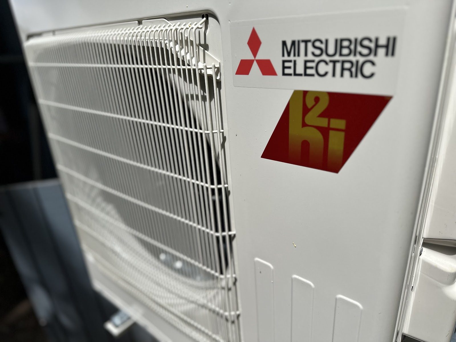 Close up of Mitsubishi Electric hyper-heat heat pump branding on a new install
