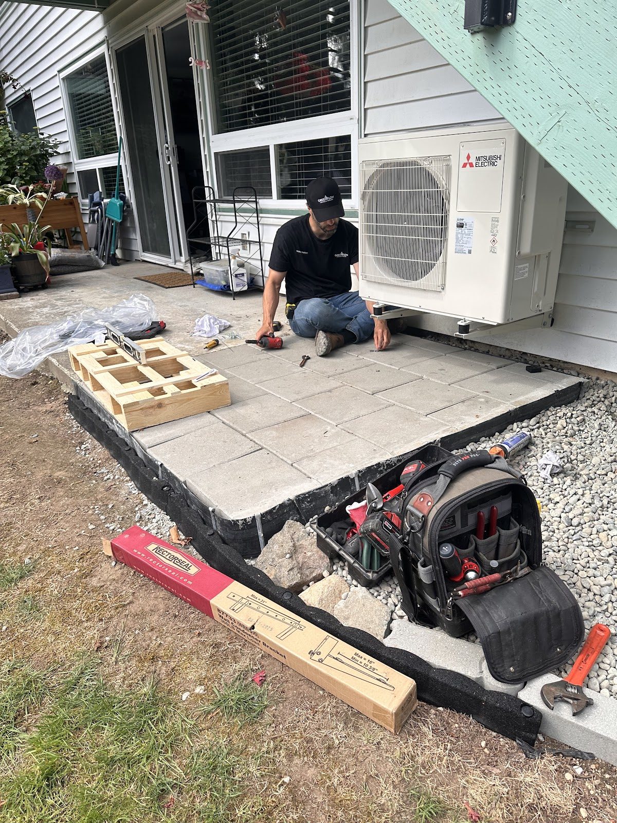 GreenFlow technician installing a new concrete pad for a ductless outdoor unit